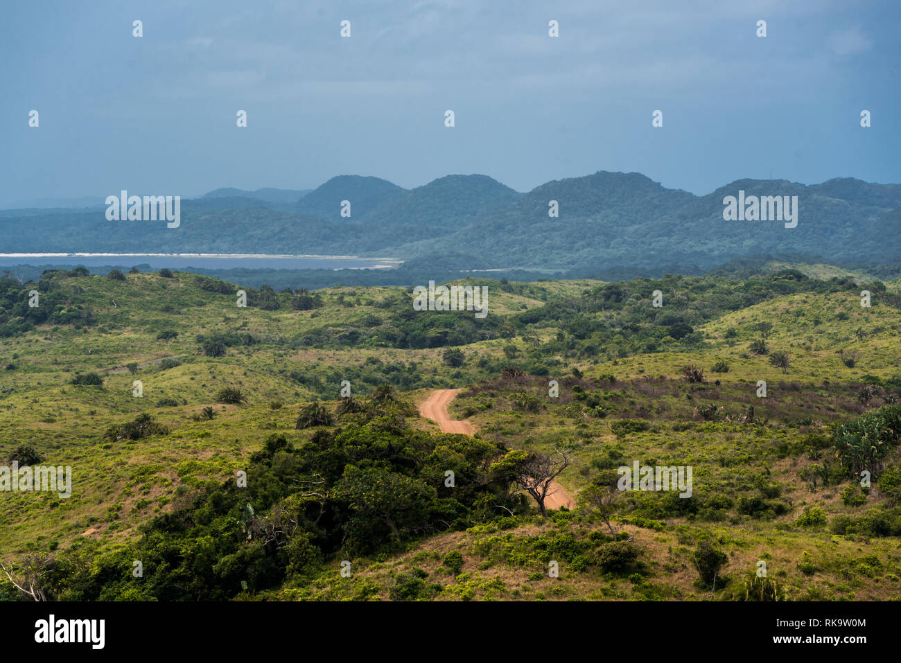 Un rosso su strada sterrata avvolgimento verso i lontani dalle dune del St Lucia estuary area in Isimangaliso Wetland Park, Sud Africa Foto Stock