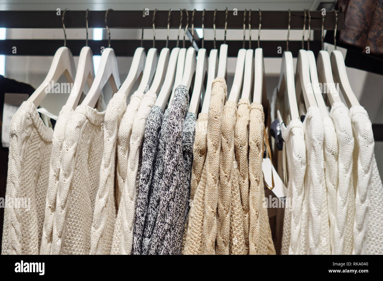 Elegante maglioni multicolore su rack Foto Stock