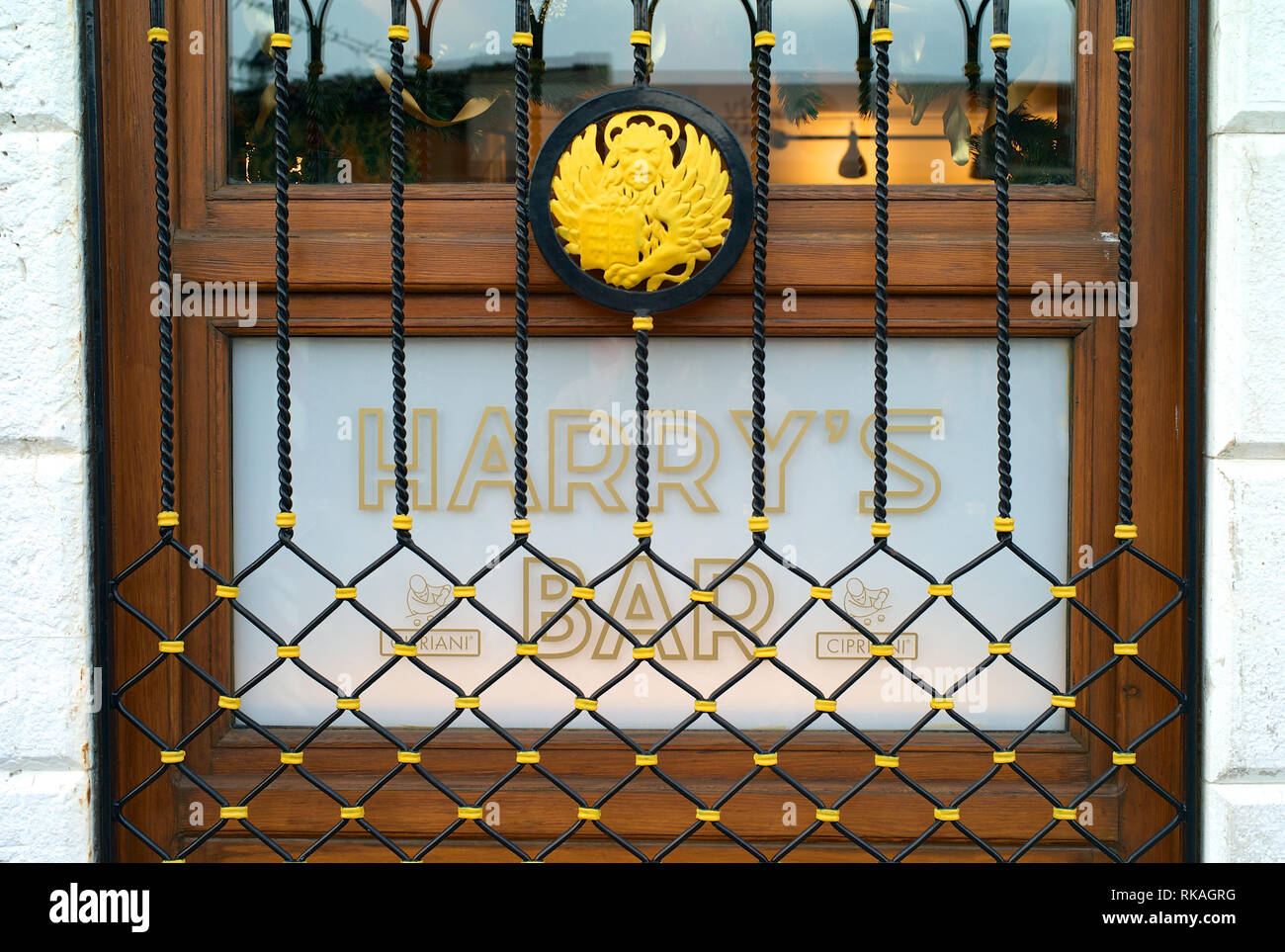Venezia, Italia - 28 dicembre 2009: la porta di legno con pannelli di vetro al famoso Harry's Bar di Venezia, Italia, con il logo e la bellissima decorat ferro Foto Stock