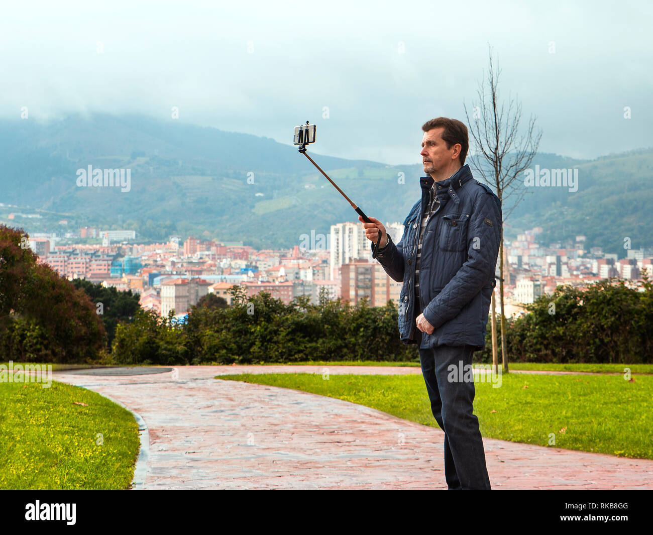 Uomo adulto con uno stile informale rendendo selfie in un parco nella città di Bilbao.Spagna Foto Stock