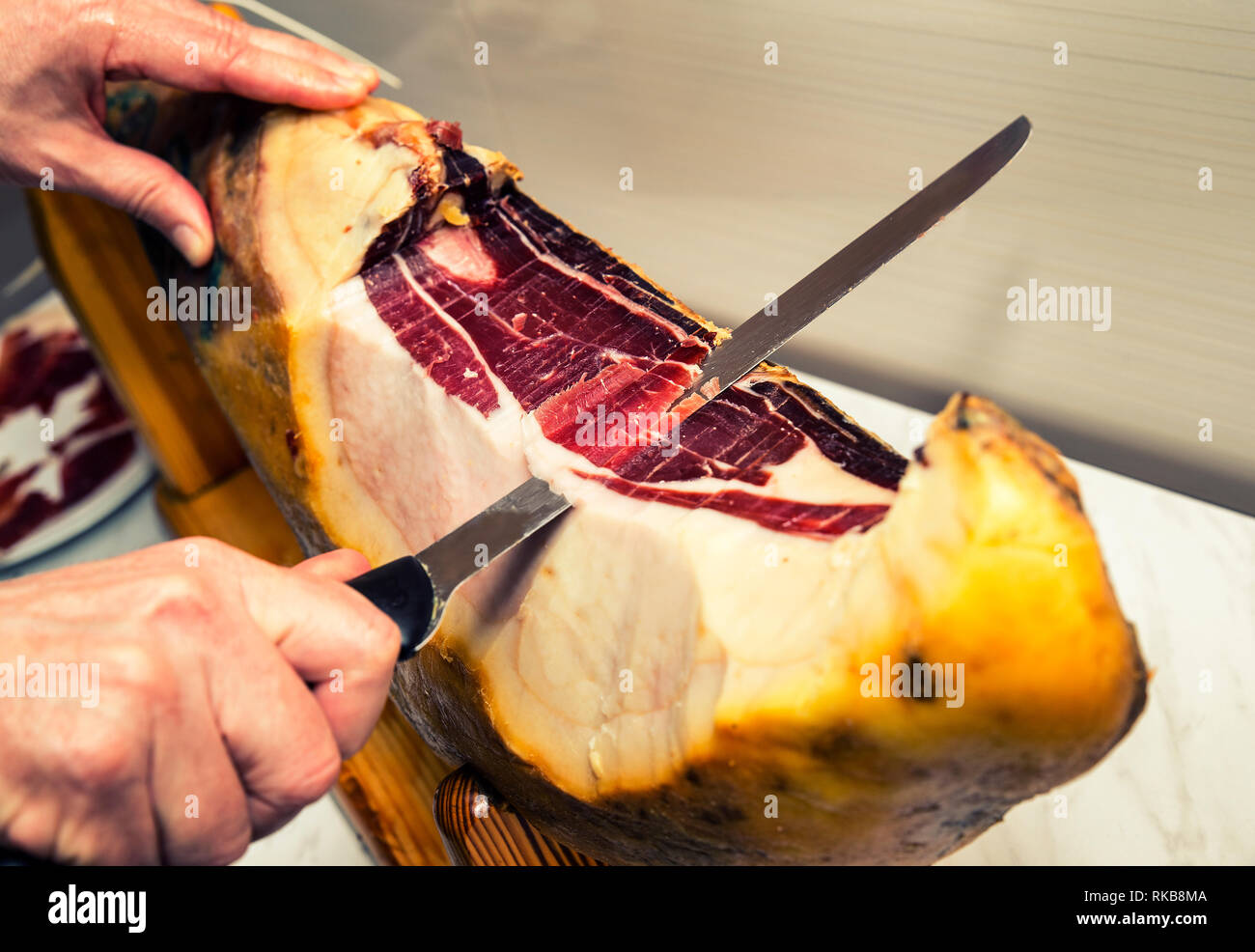 Vista di una mano e il coltello Slicing Spanish ham" Foto Stock