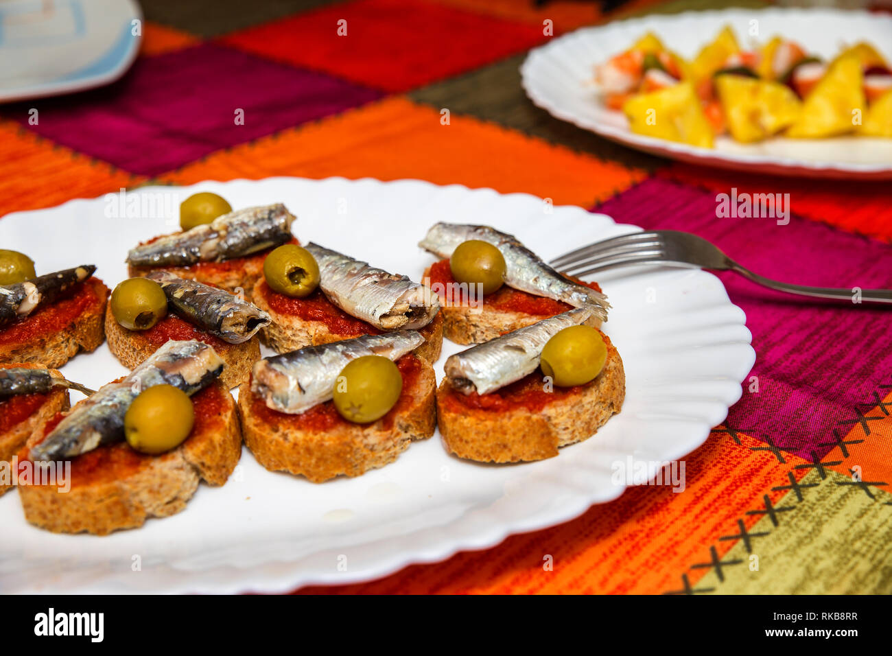 Vista in pianta di una piastra con le sardine e oilves sul pane Foto Stock