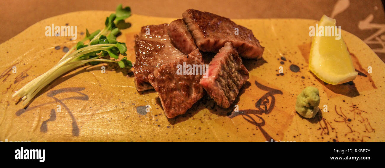 Piacevolmente disposta Wagyu manzo con rafano, limone e vegetali ad un ristorante in Kyotango, Giappone Foto Stock