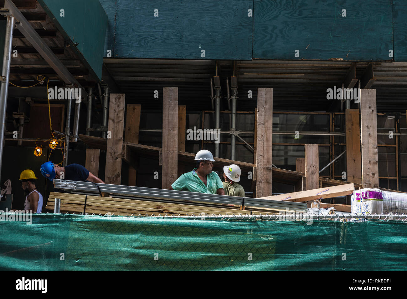 La città di New York, Stati Uniti d'America - 27 Luglio 2018: lavoratori edili che trasportano il materiale di costruzione lungo una strada di Manhattan a New York City, Stati Uniti d'America Foto Stock