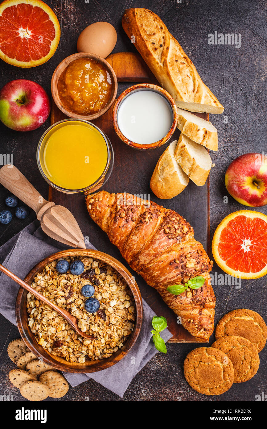 Una sana prima colazione bilanciata su uno sfondo scuro. Muesli, latte,  succo di frutta, croissant vista dall'alto Foto stock - Alamy