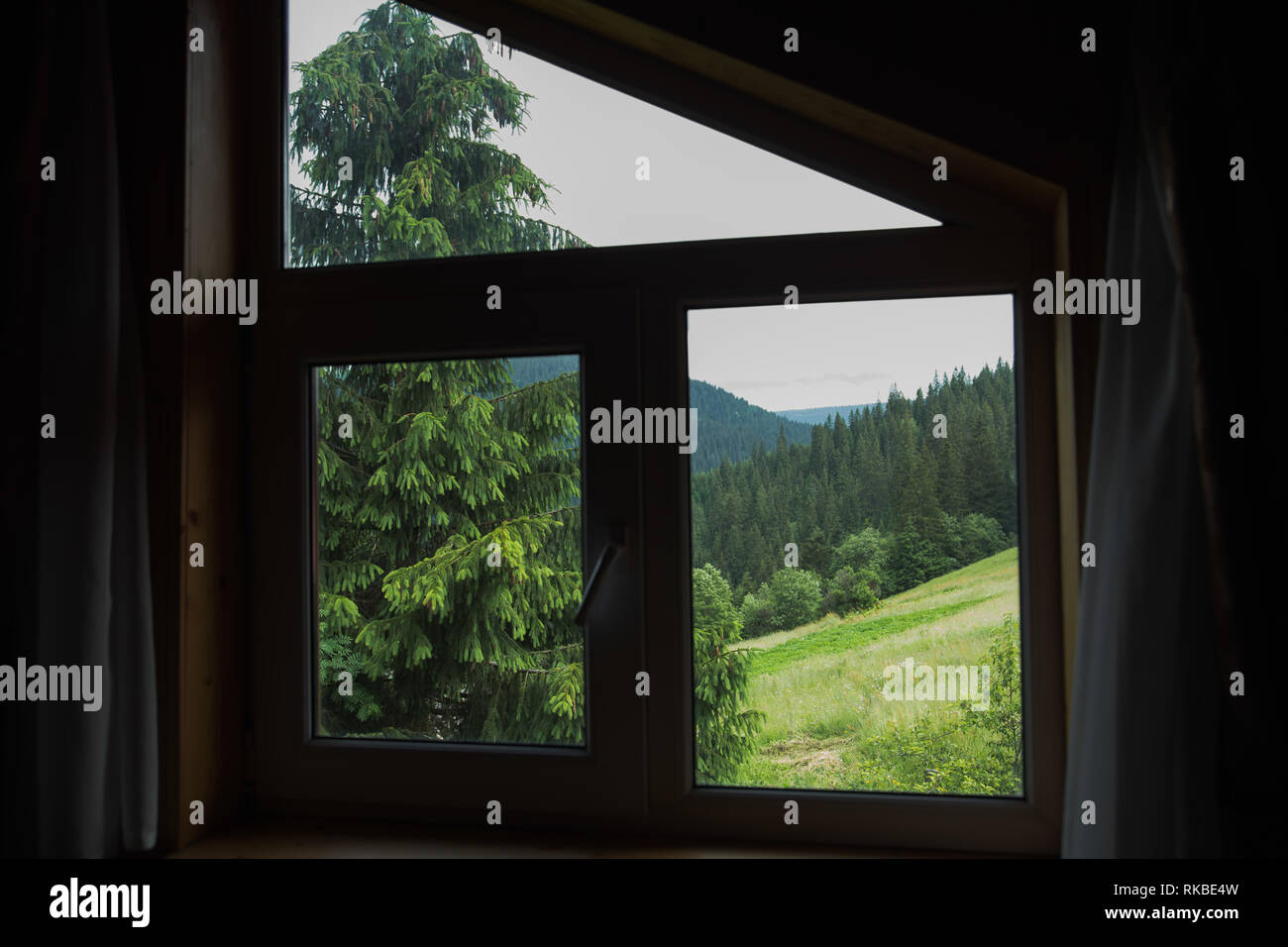 Incredibile vista green attraverso la finestra in legno rustico in campagna. Orizzontale fotografia a colori. Foto Stock