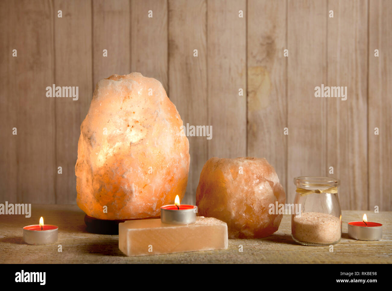 Sale Himalayano saponetta, rosa rock spia sale accesa e il sale portacandele, con candela che brucia, jar con grani di sale sulla luce bokeh backgro Foto Stock