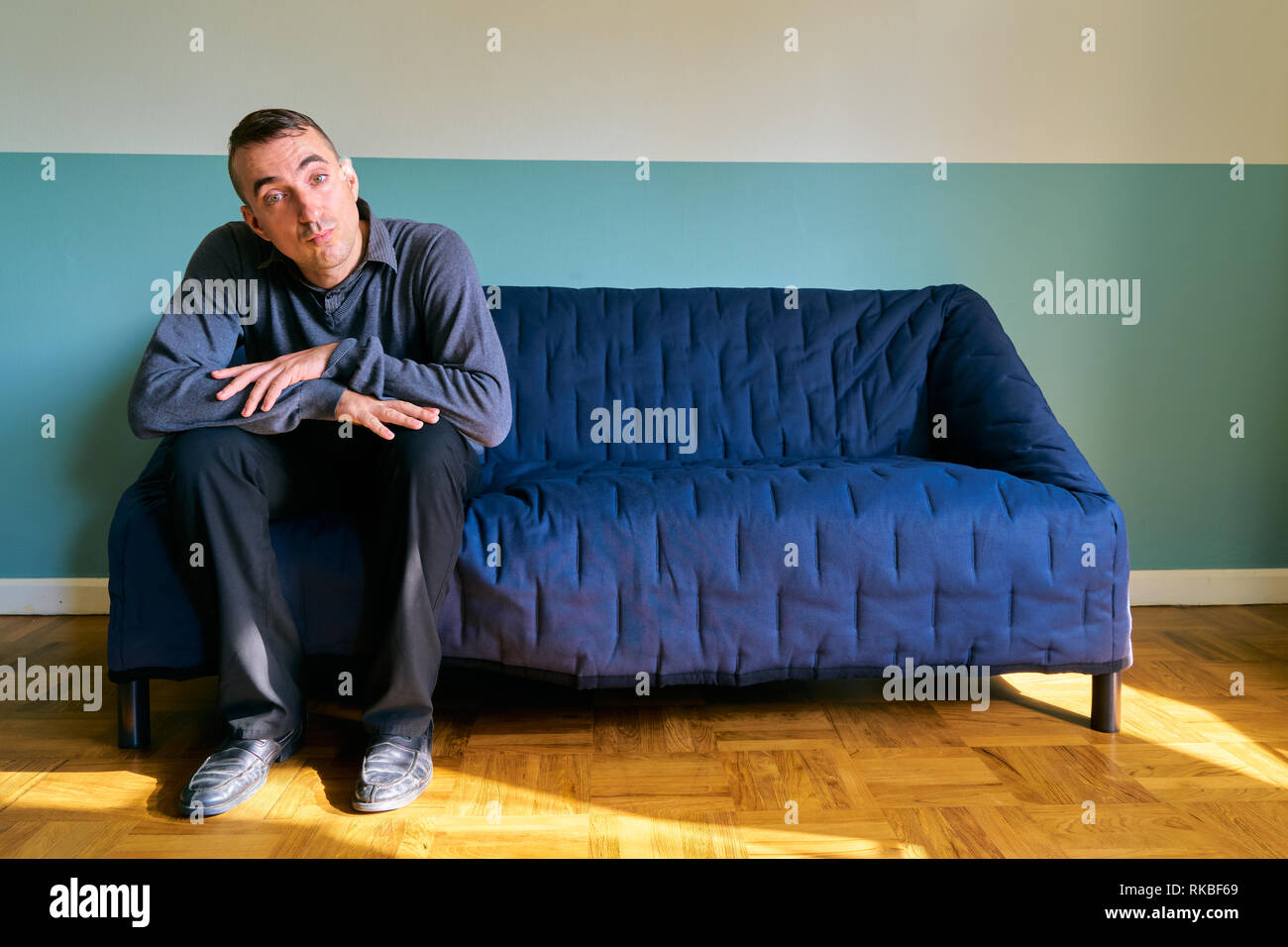 Bel ragazzo in posa - lazy uomo seduto sul divano Foto Stock