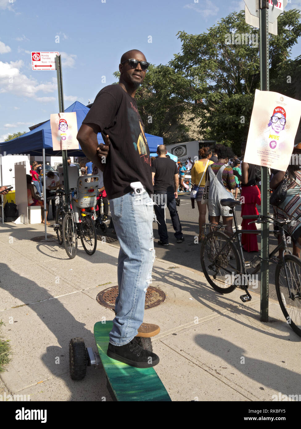 Uomo di fronte gli annunci per Spike Lee 9 blocco annuale Pary in Bedford Stuyvesant sezione di Brooklyn, Aug.26, 2017. Foto Stock