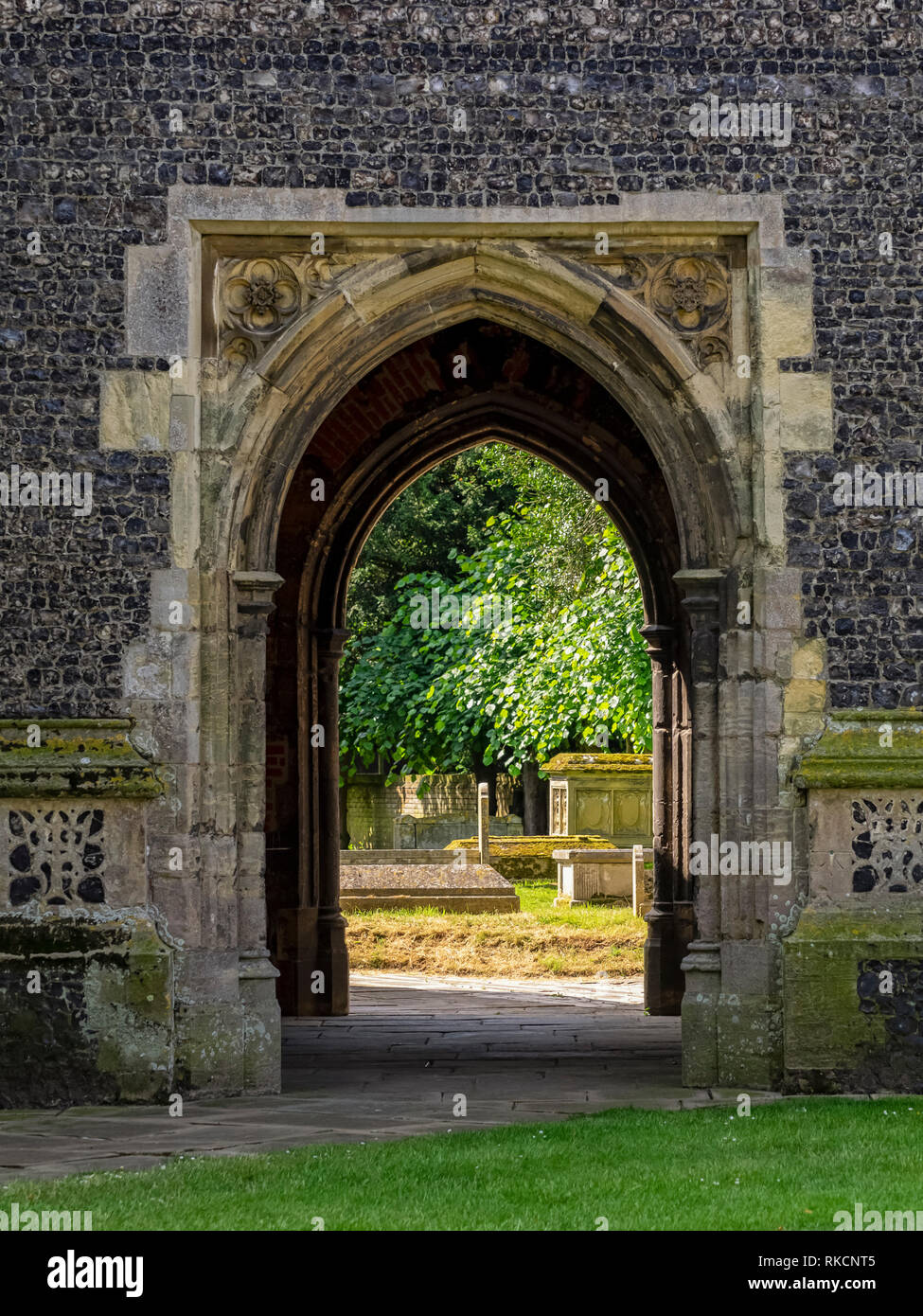 DEDHAM ESSEX, UK - 13 GIUGNO 2018: Vista attraverso l'arco alla base della Torre della Chiesa di Santa Maria fino al cimitero Foto Stock