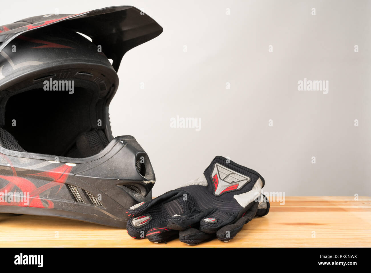 Moto abbigliamento protettivo - motocross casco e guanti di protezione su  un sfondo di legno. Copia spazio sulla destra Foto stock - Alamy