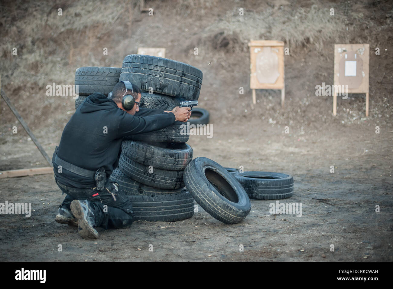 Pistola di combattimento addestramento al tiro da dietro e intorno al coperchio o barricade. Advanced combattimenti tattici corsi di tiro sul poligono di tiro Foto Stock