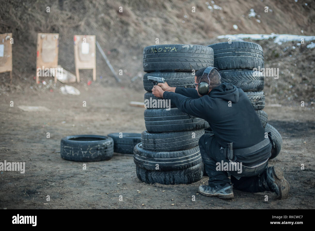 Pistola di combattimento addestramento al tiro da dietro e intorno al coperchio o barricade. Advanced combattimenti tattici corsi di tiro sul poligono di tiro Foto Stock