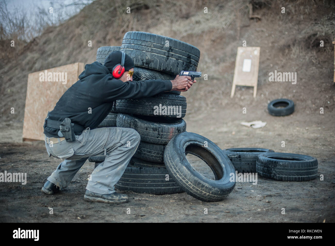 Pistola di combattimento addestramento al tiro da dietro e intorno al coperchio o barricade. Advanced combattimenti tattici corsi di tiro sul poligono di tiro Foto Stock