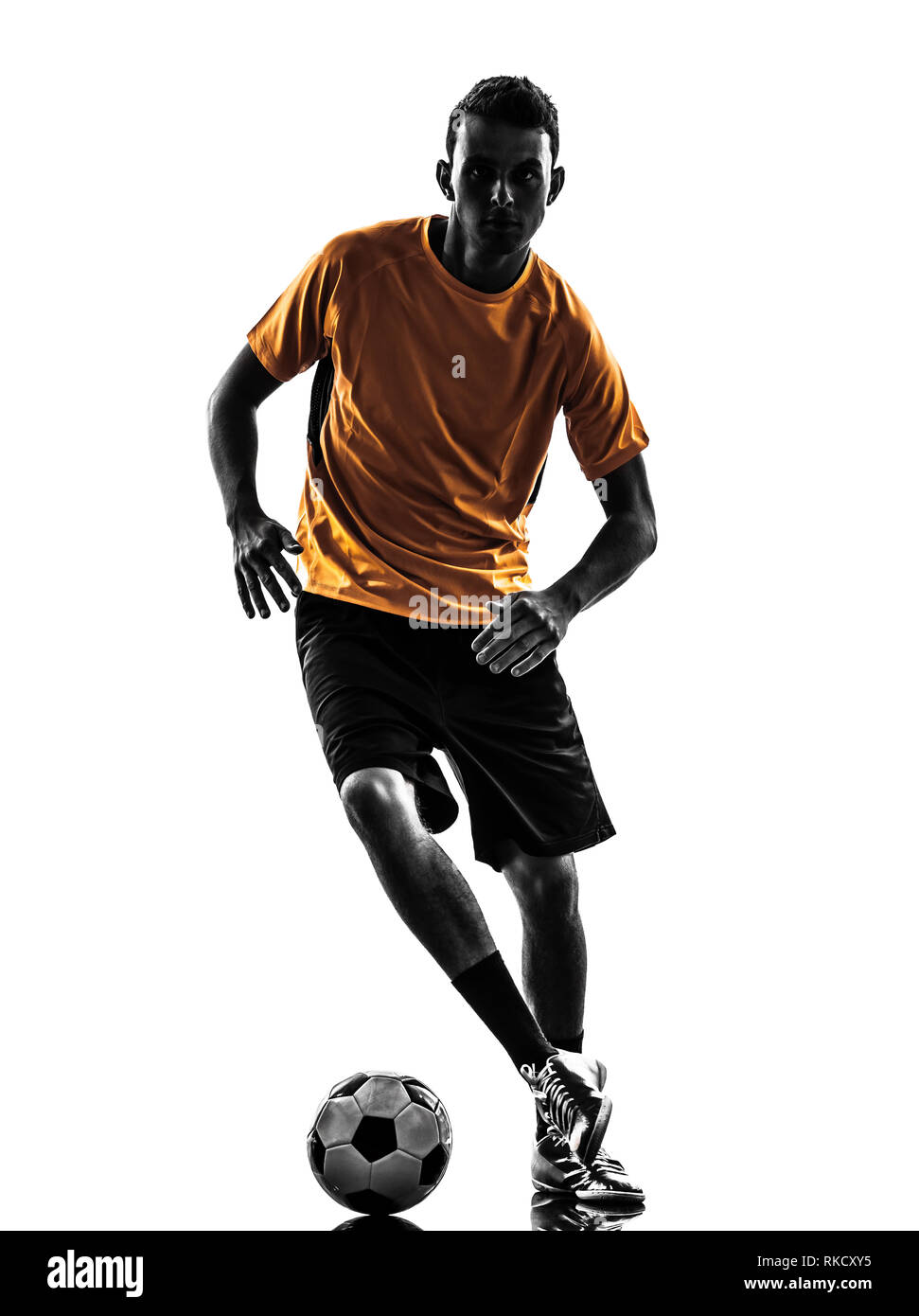 Un giovane giocatore di calcio maglia arancione in silhouette su sfondo bianco Foto Stock