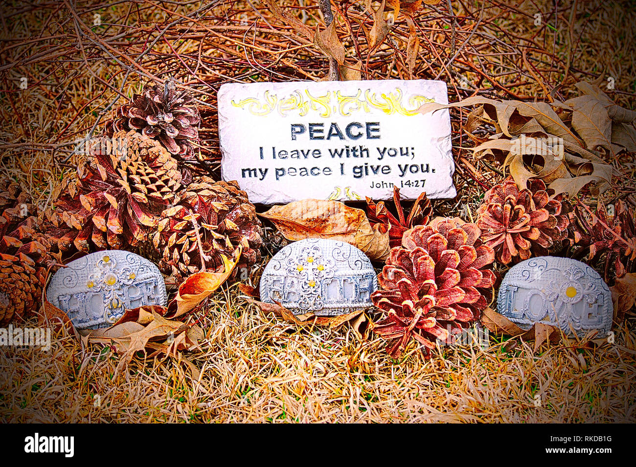 Close-up di diverse pigne nelle quali sul terreno con foglie, vigne, una citazione dalla Bibbia e tre pietre artigianali che hanno simboli su di essi e la Foto Stock