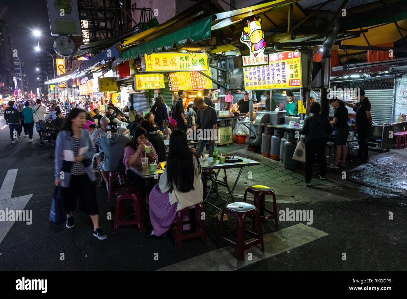 I residenti di Taipei acquistare cibo da alimentare ai fornitori di stallo ad un cibo locale del mercato notturno in Daan District in Taipei, Taiwan, dove mangiare o prendere la distanza. Foto Stock