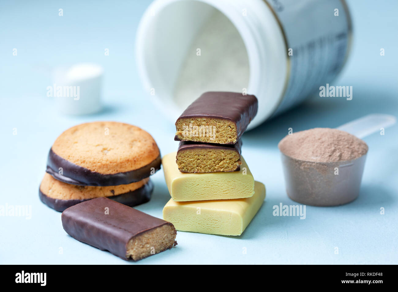 Nutrizione Sportiva: barre della proteina, la proteina cookie, proteine in polvere su uno sfondo blu Foto Stock