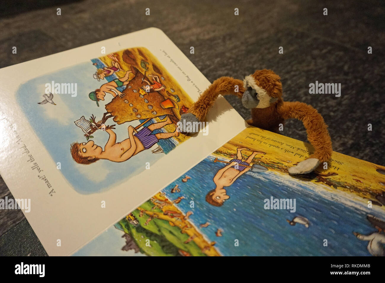 Giocattolo scimmia morbida la lettura di un libro per bambini Foto Stock