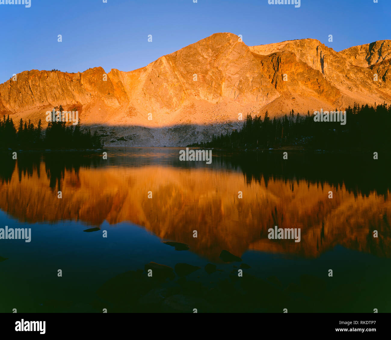 Stati Uniti d'America, Wyoming Medicine Bow Routt National Forest, Sunrise sulle Medicine Bow picco riflette nelle calme acque del lago di Marie nel campo nevoso. Foto Stock