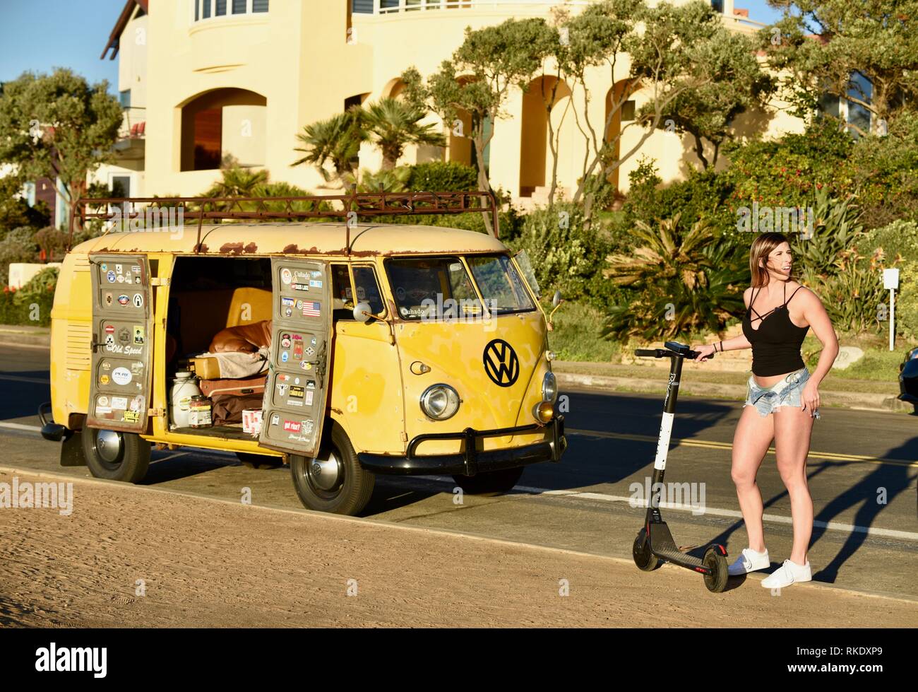 Attraente giovane donna hopping su Bird scooter elettrico accanto al  classico Volkswagon VW minibus camper parcheggiato a Sunset Cliffs, San  Diego, Stati Uniti d'America Foto stock - Alamy