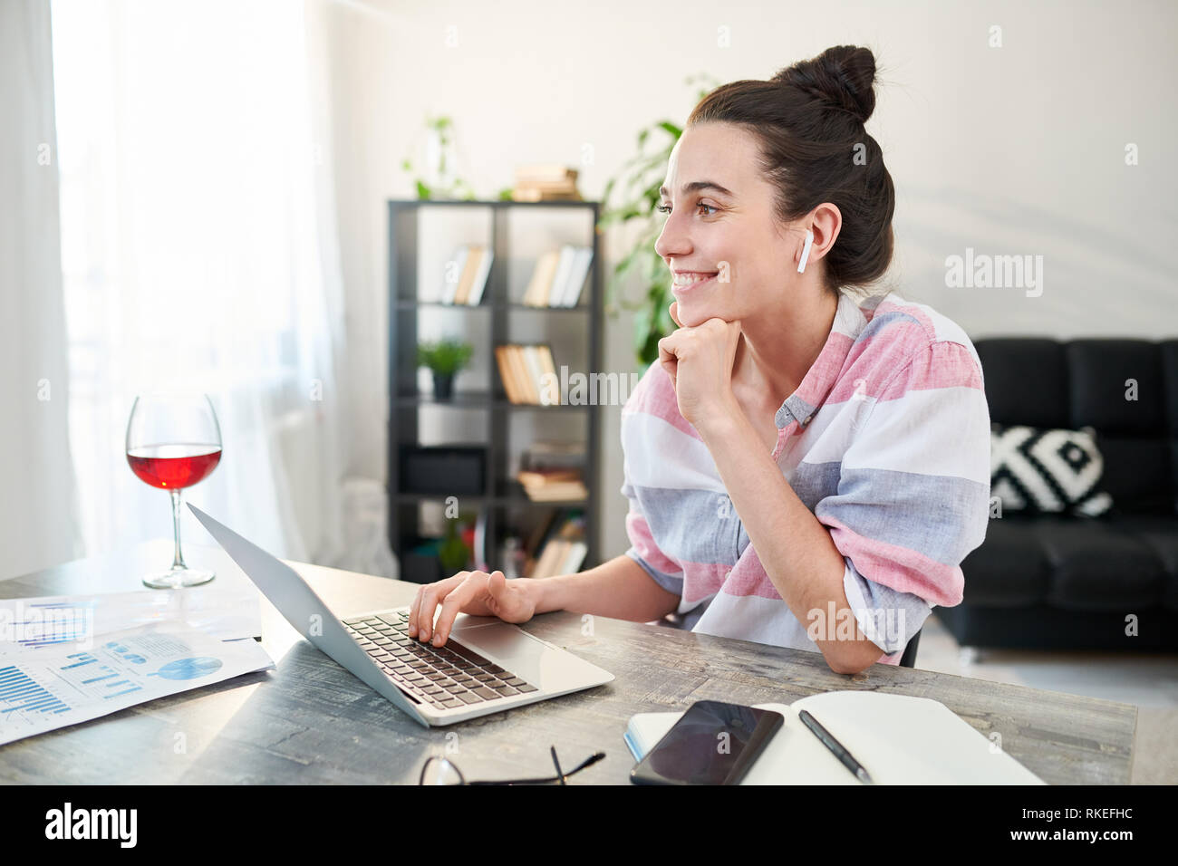 Felice giovane donna che lavora da casa Foto Stock