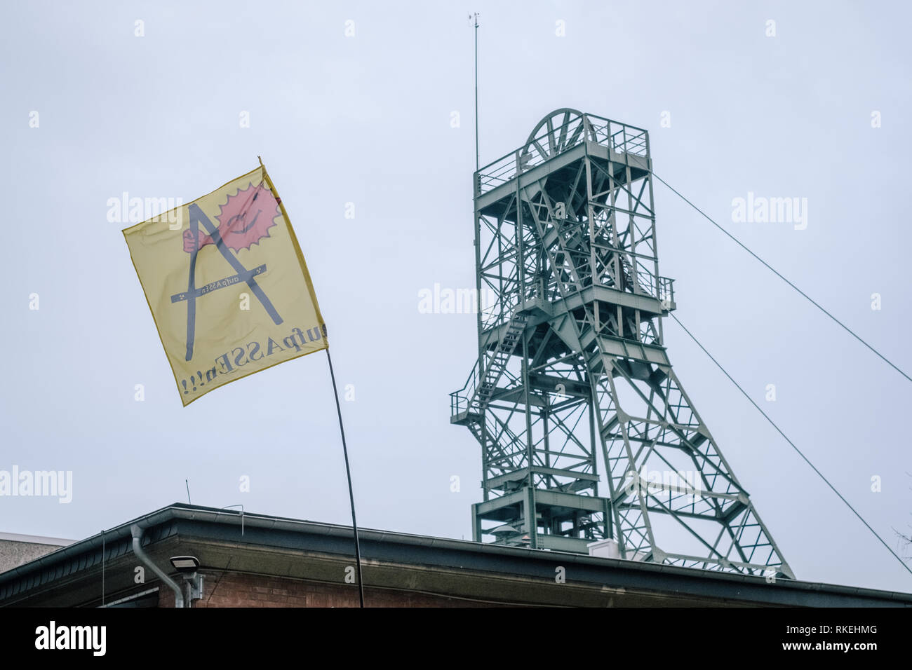 Remmlingen, Germania. 07 feb 2019. Una bandiera di anti-nucleare "rete AufpASSEn e.V. " è volare accanto alla torre di avvolgimento dell'Asse miniera. In Asse in Remlingen vicino a Wolfenbüttel, intorno a 126.000 barili di basso o medio livello di residui radioattivi sono state conservate per più di cinquant'anni. Poiché l'acqua penetra nella miniera fatiscente giornaliero, vi è un ordine giuridico per arrestare l'Asse II immediatamente. Credit: Ole Spata/Ole Spata/dpa/Alamy Live News Foto Stock