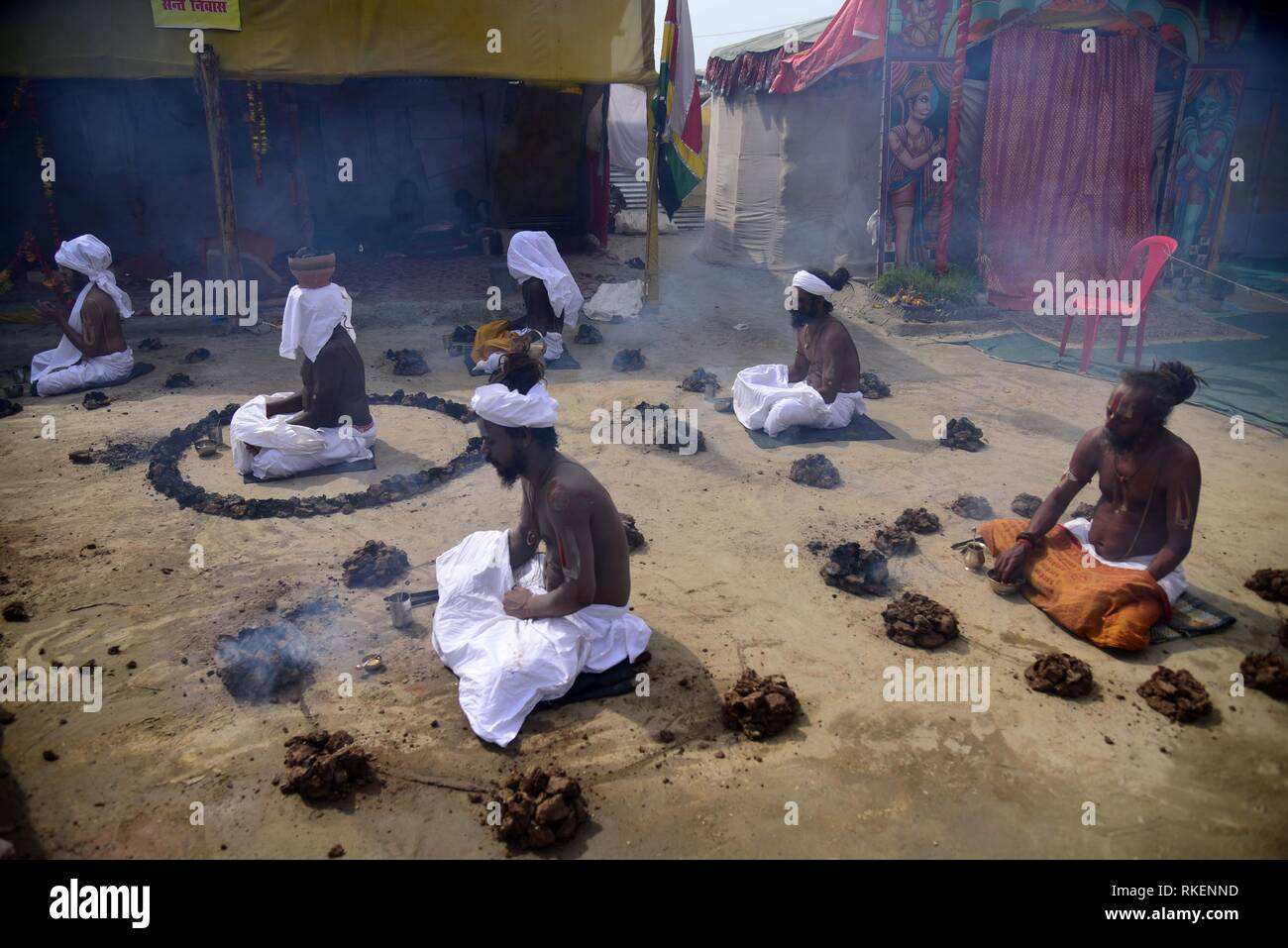 Di Allahabad, Uttar Pradesh, India. Xi Febbraio, 2019. Sadhu indiano (Hindu uomo santo) brucia essiccato sterco di vacca come parte di un rituale religioso a Sangam -- la zona intorno alla confluenza dei fiumi Gange e Yamuna, e mitico Saraswati il Kumbh Mela in Allahabad su 11-02-2019. Credito: Prabhat Kumar Verma/ZUMA filo/Alamy Live News Foto Stock