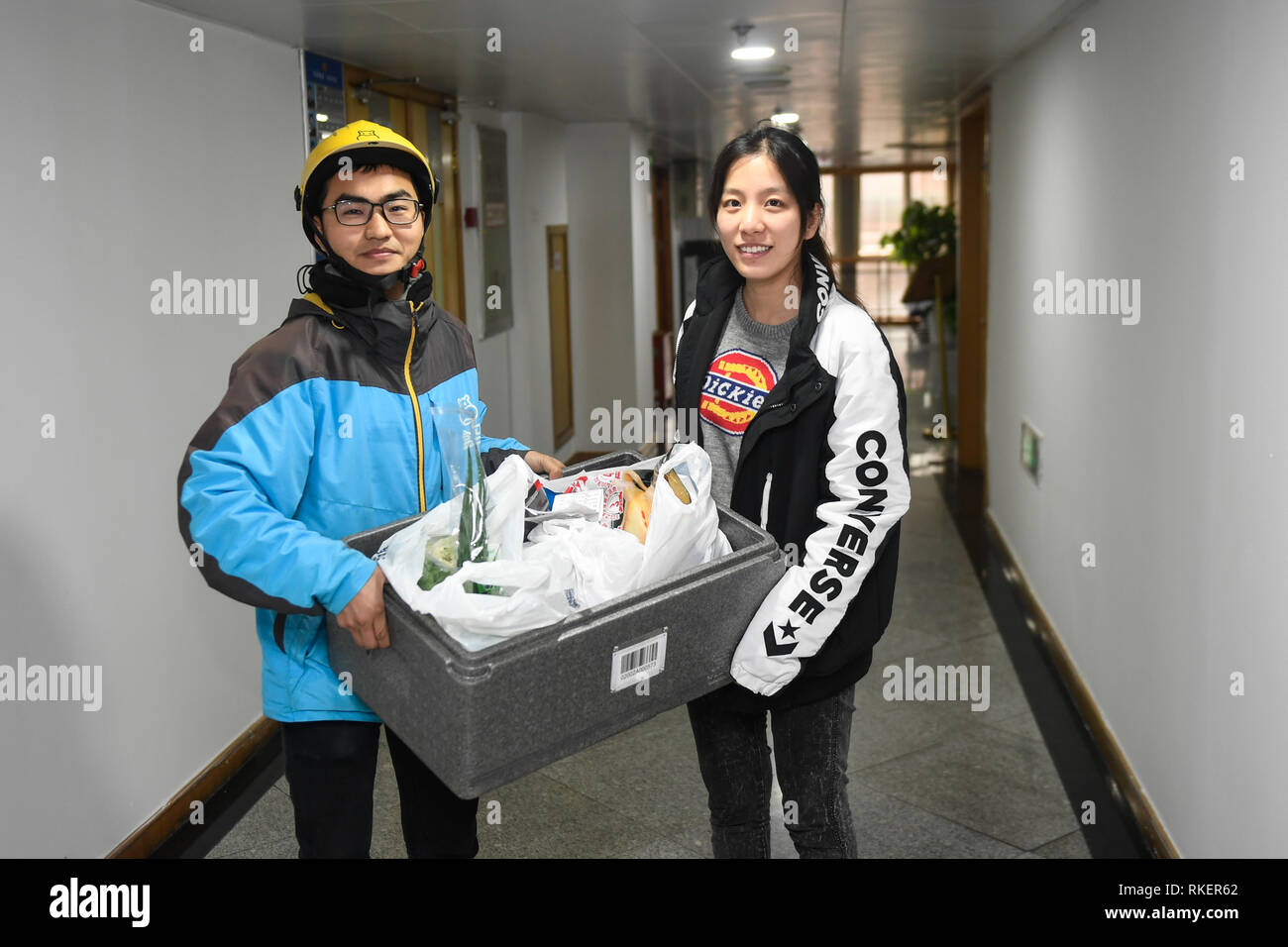 Pechino, cinese della Provincia di Zhejiang. 3 febbraio, 2019. Zhou Xiaoyu (R) riceve gli ingredienti freschi per il ricongiungimento familiare la cena Cinese Capodanno da un deliveryman in Hangzhou, est della Cina di Provincia dello Zhejiang, Febbraio 3, 2019. Credito: Huang Zongzhi/Xinhua/Alamy Live News Foto Stock