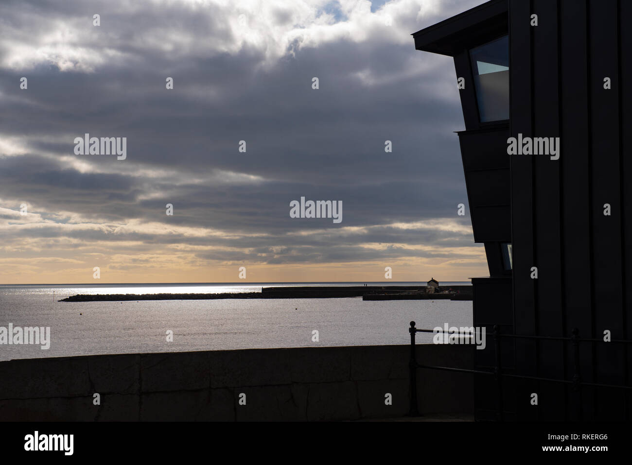 Lyme Regis, Dorset, Regno Unito. Xi Febbraio 2019. Regno Unito: Meteo un luminoso giorno con abbondanza di sunny incantesimi nella località costiera comune di Lyme Regis. Una veduta distante da Lyme Regis Museum con la mitica Cobb stagliano contro il mare scintillante nella distanza. Credito: Celia McMahon/Alamy Live News Foto Stock
