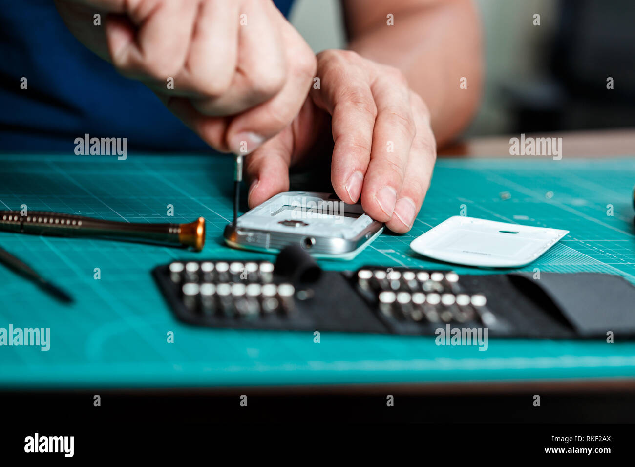 Elettronica per il servizio di riparazione. Il tecnico dello smartphone di smontaggio per ispezione Foto Stock