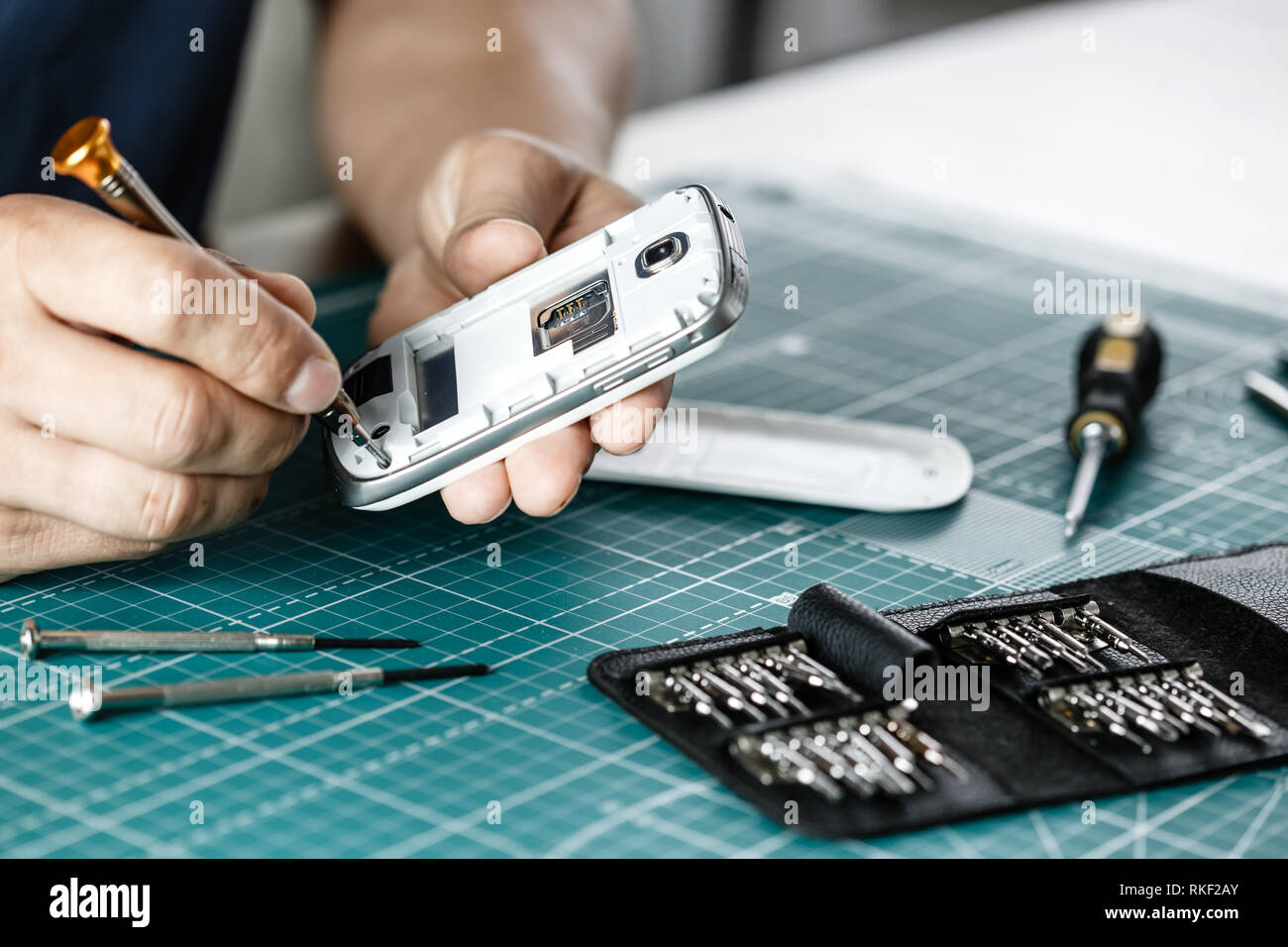 Elettronica per il servizio di riparazione. Il tecnico dello smartphone di smontaggio per ispezione Foto Stock