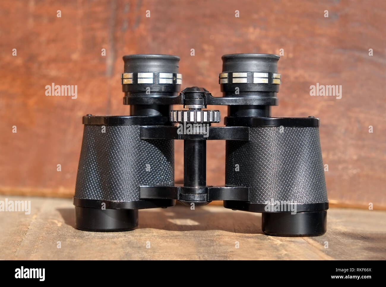 Vecchio prisma colore nero binocolo su vintage sfondo di legno vista frontale closeup Foto Stock