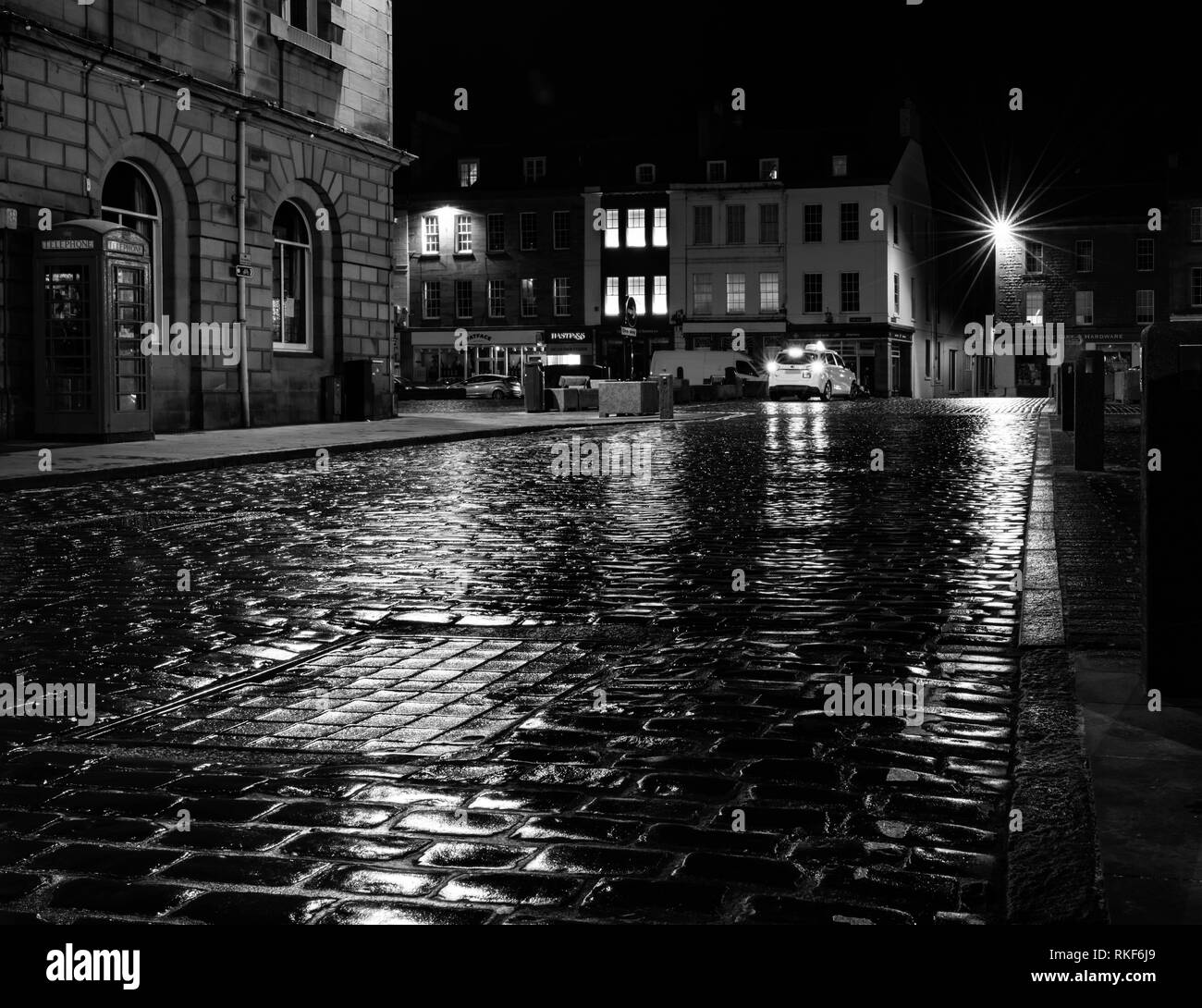La strada acciottolata bagnata dalla pioggia di notte, Kelso Foto Stock