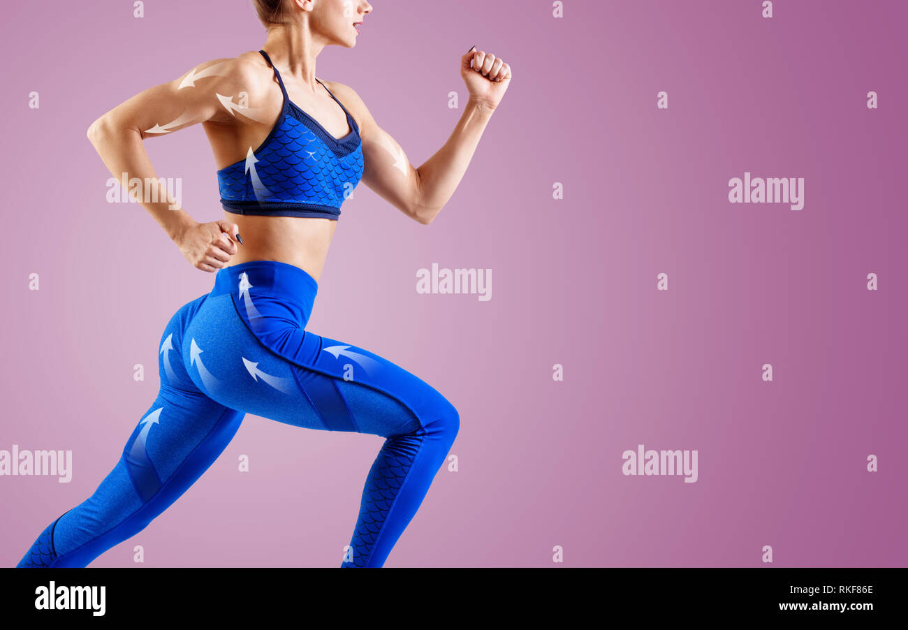 Giovane donna runner in blu sportswear saltare in aria. Movimento dinamico. Foto Stock