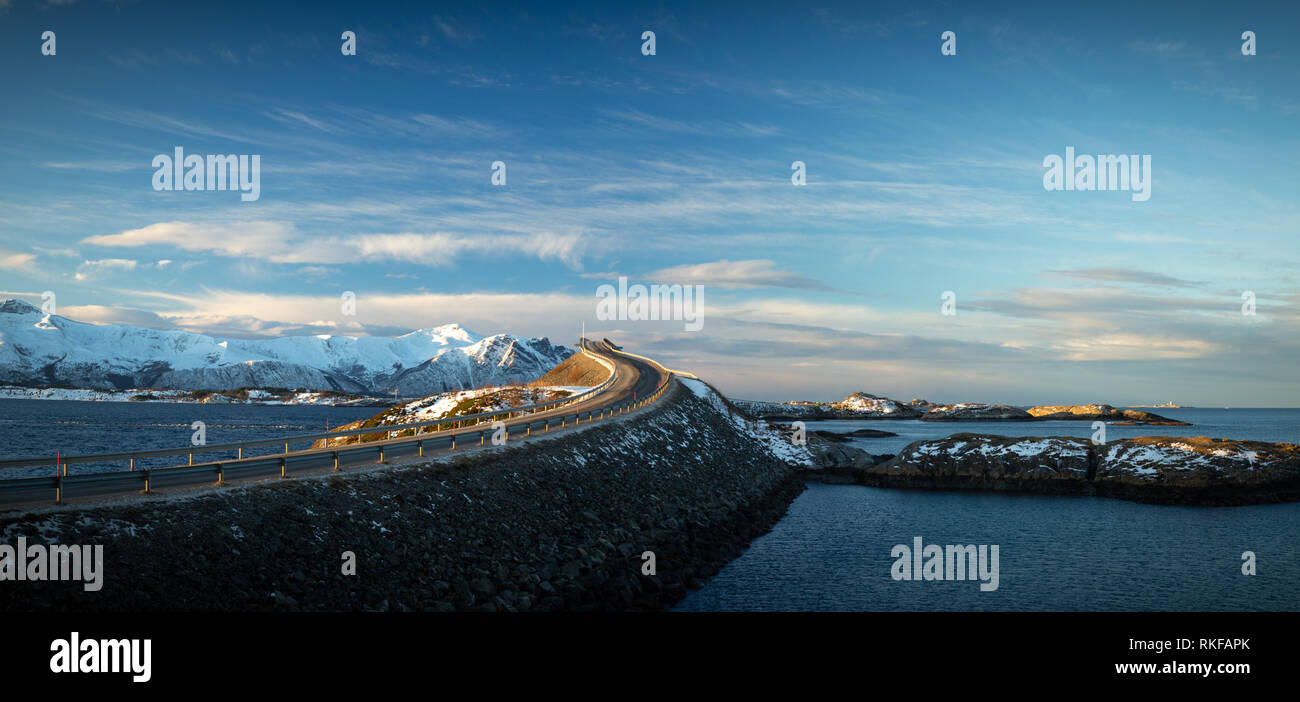 Oceano atlantico Road - Atlanterhavsvegen in inverno giornata di sole. Famoso ponte alto sul mare chiamato Storseisundbrua e bellissime montagne innevate in un Foto Stock