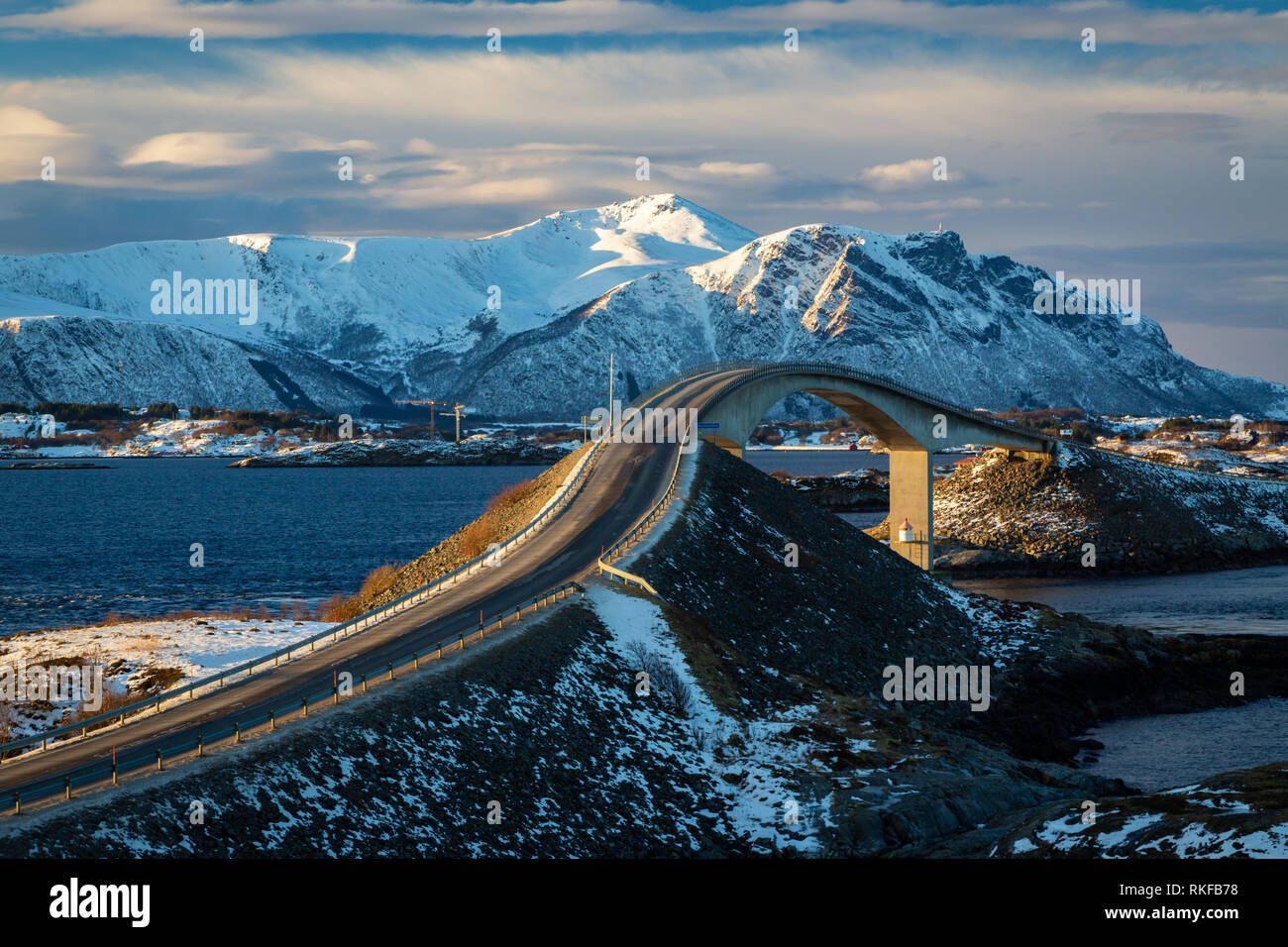 Oceano atlantico Road - Atlanterhavsvegen in inverno giornata di sole. Famoso ponte alto sul mare chiamato Storseisundbrua e bellissime montagne innevate in un Foto Stock