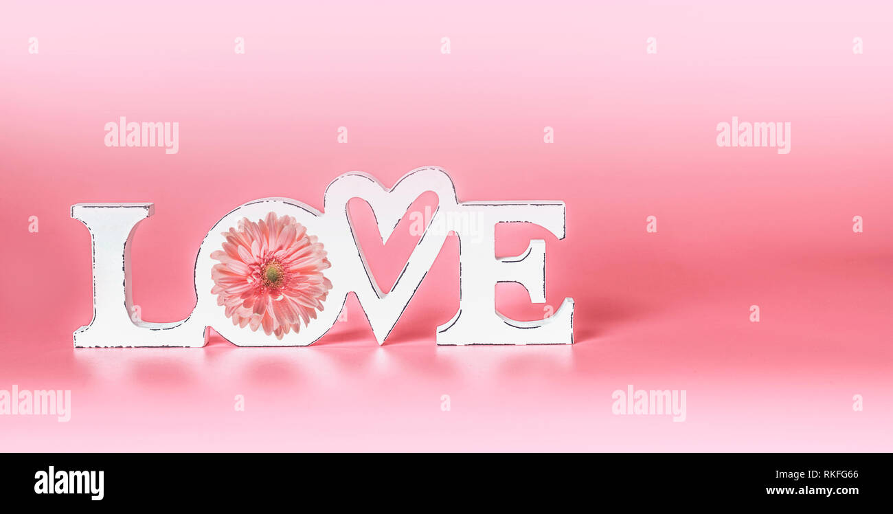Il concetto di amore con il bianco la parola amore a pastello sfondo rosa. Creatività romantica layout. Scheda di nozze. Copia dello spazio. Banner. Biglietto di auguri Foto Stock