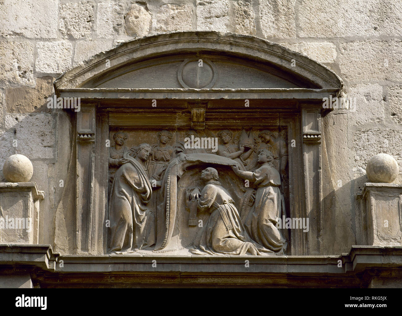 Spagna, la Comunità di Madrid Alcala de Henares. San Ildefonso cappella. Esso è stato costruito come una Chiesa Universitaria, 1500-1520 da Pedro de Villaroel dopo un design da Pedro Gumiel. Facciata. Dettaglio del timpano con sculptoric raffigurazione della Vergine che impone la casula su San Ildefonso. Foto Stock