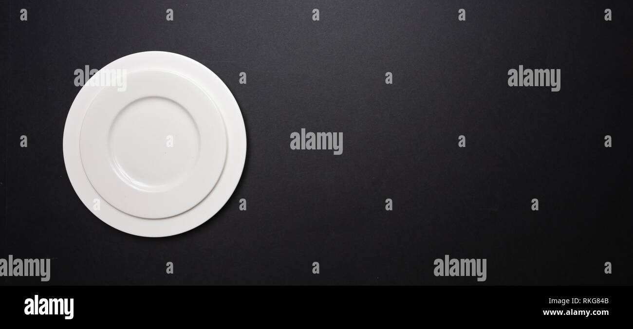 Set di svuotare le piastre bianche su nero colore di sfondo, banner, vista dall'alto, spazio di copia Foto Stock