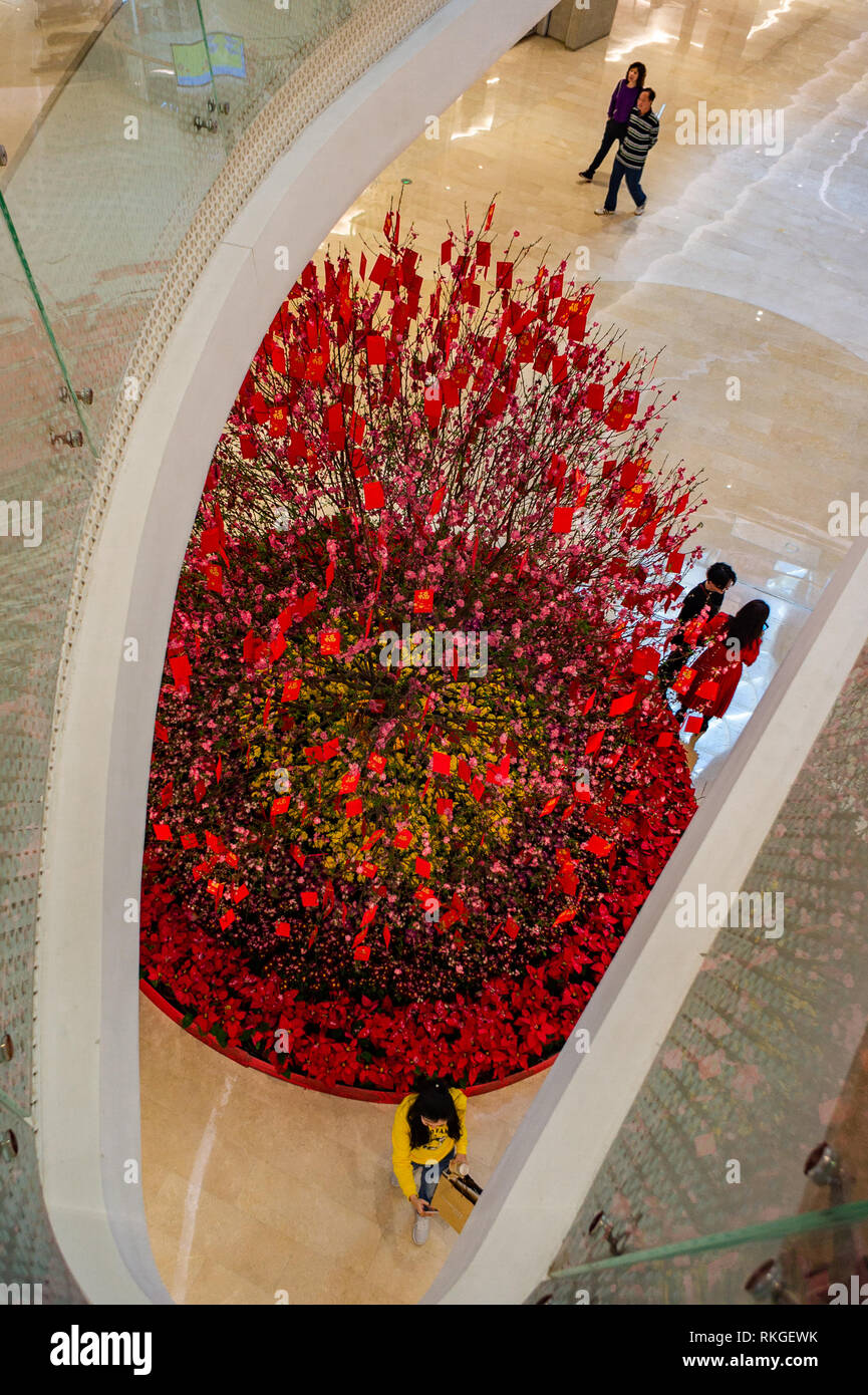Wishing Tree dal di sopra, con buste rosse per la buona fortuna e la donna prendendo un selfie durante il Nuovo Anno Lunare di Shenzhen, Cina Foto Stock