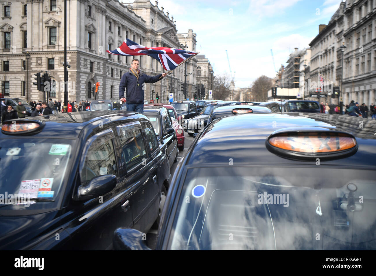 I tassisti bloccano la strada durante una manifestazione di protesta al di fuori della sede del parlamento di Londra nella ultima fase di proteste in corso contro TFL e autorità locali che stanno limitando il loro accesso a parti di Londra. Foto Stock