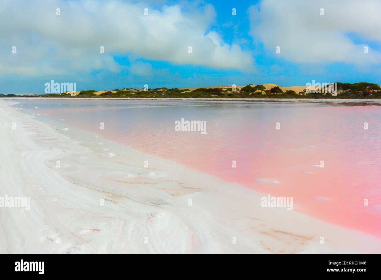 Bellissimo lago rosa Hillier in Western Australia, sale e acqua naturale paesaggio colorato contro nuvoloso cielo blu e morbido acqua liscia. Foto Stock