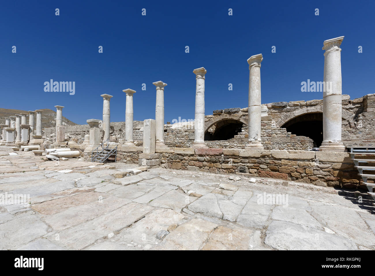 Hierapolis Street, una delle principali arterie della città in background è arcuata di edificio, Tripolis sul meandro, Yenicekent, Turchia. L'Ar Foto Stock