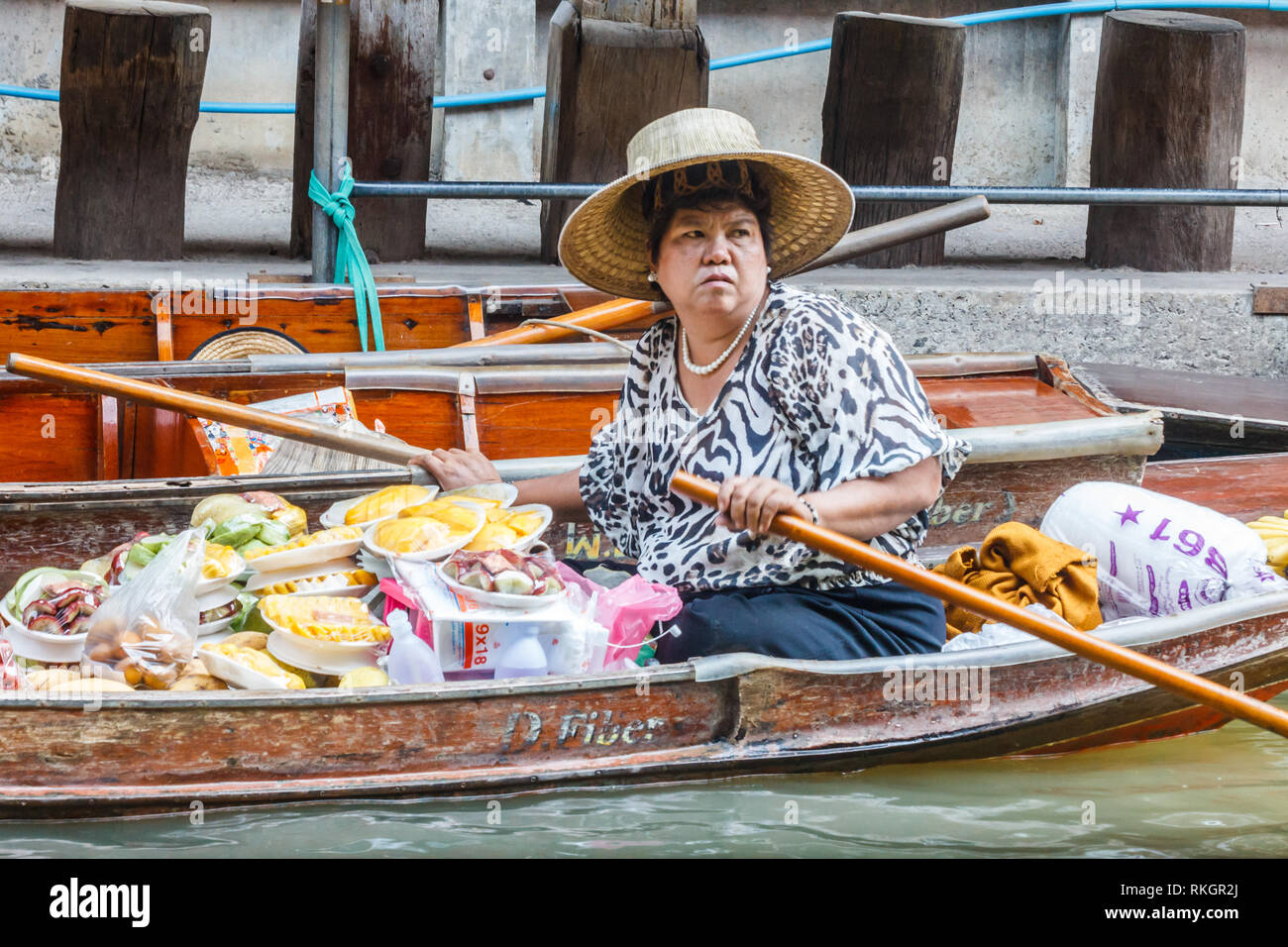 Damnoen Saduak, Tailandia - 4 Marzo 2017: fornitore di frutta pagaie la sua barca. Il mercato galleggiante è una meta turistica molto atrraction Foto Stock