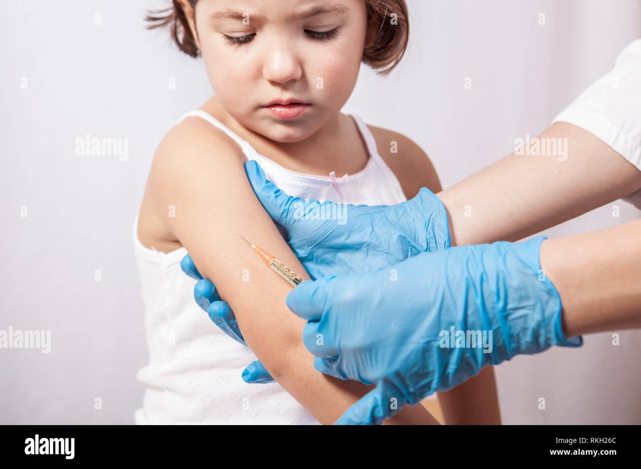 La vaccinazione di infermiere 3 anni bambina. Ella è preoccuparsi di doloroso stitch. Foto Stock