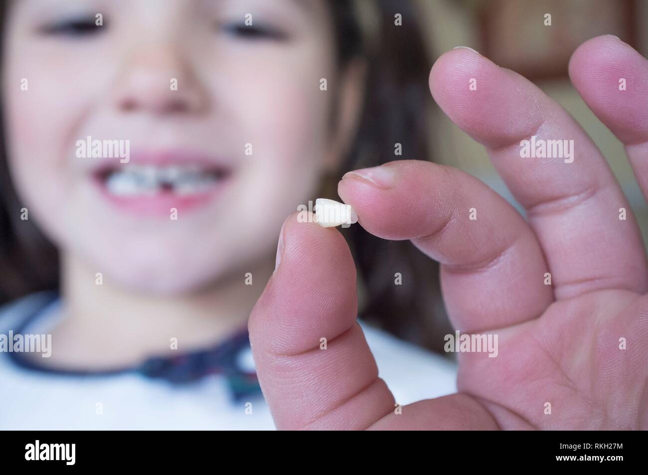 Poco più di 5 anni ragazza mostrando il suo primo bambino dente caduto fuori. Primo piano. Foto Stock