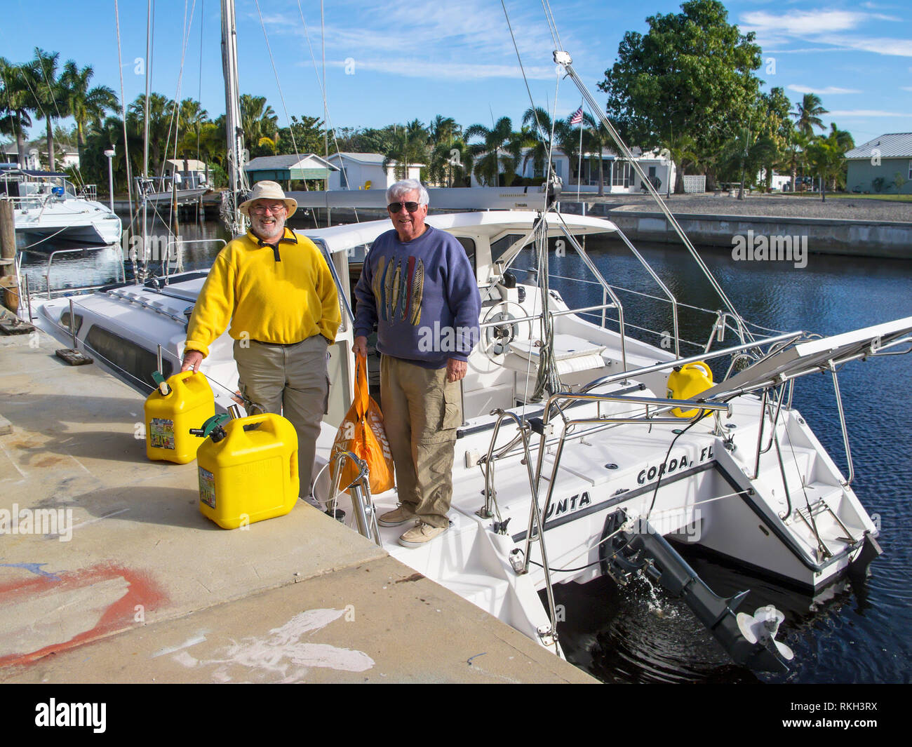 2 alti uomini; catamarano a vela; sorridente; felice; divertimento; sport; amici; bombolette di gas, calcestruzzo dock, viaggio; attività marine; inverno; Florida; Orizzontale; signor Foto Stock