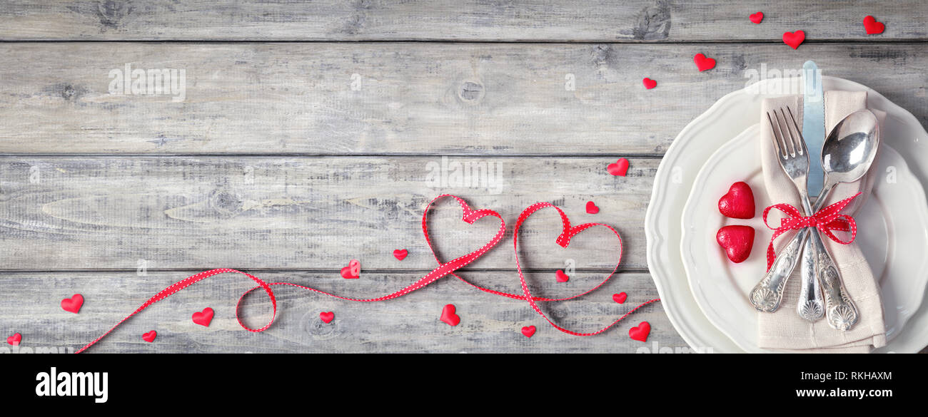 Romantico e tavolo - Argenteria Vintage piatto con cioccolatini Ribbon e tovagliolo sulla tavola in legno Foto Stock