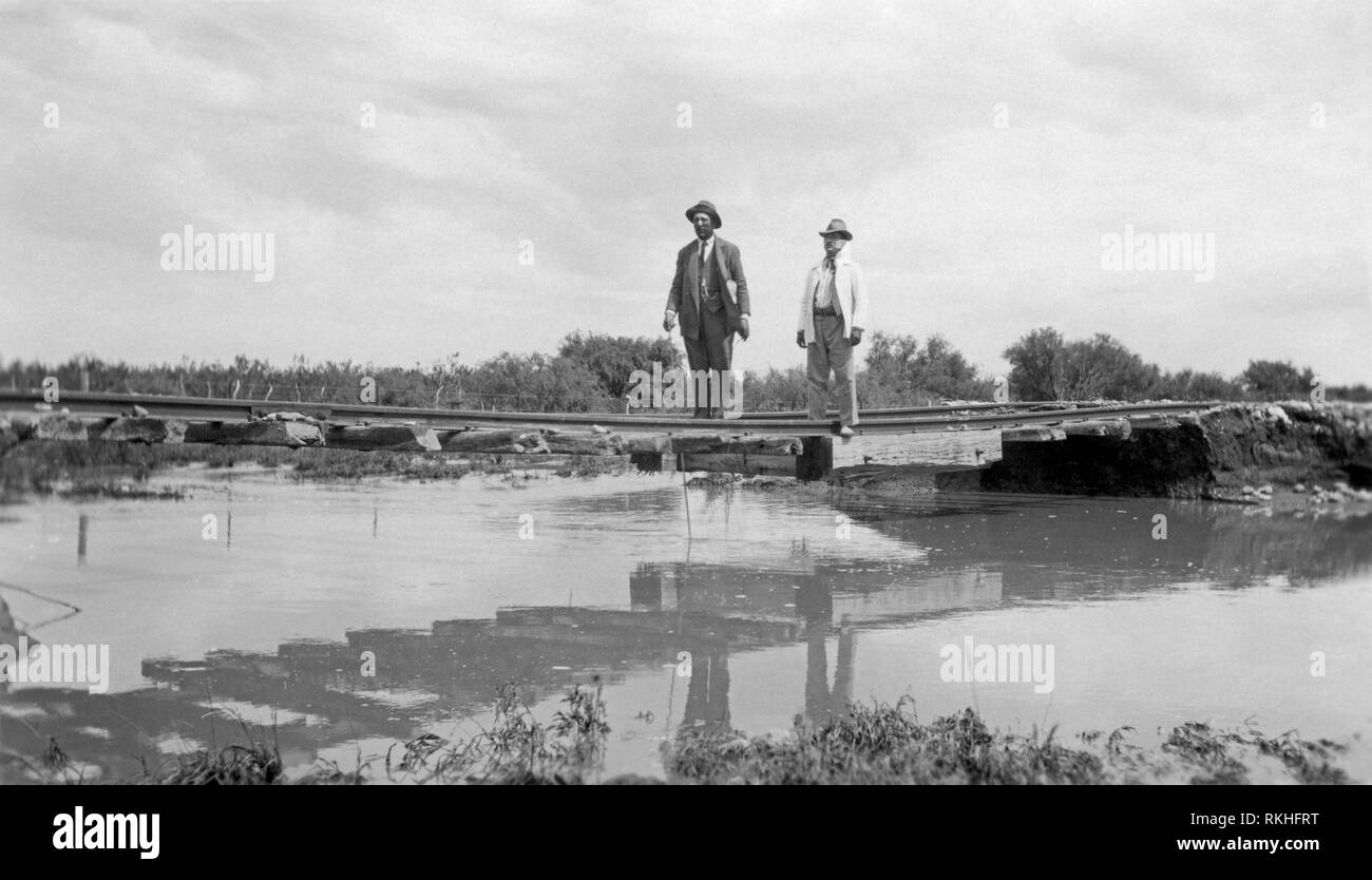 Ispezione di danni ai binari appeso sopra l'acqua dove il terrapieno è stato lavato via dalle inondazioni lungo il ramo ferroviario della linea di collegamento tra il Retiro e San Rafael, Mendoza, Argentina, c. 1930s Foto Stock